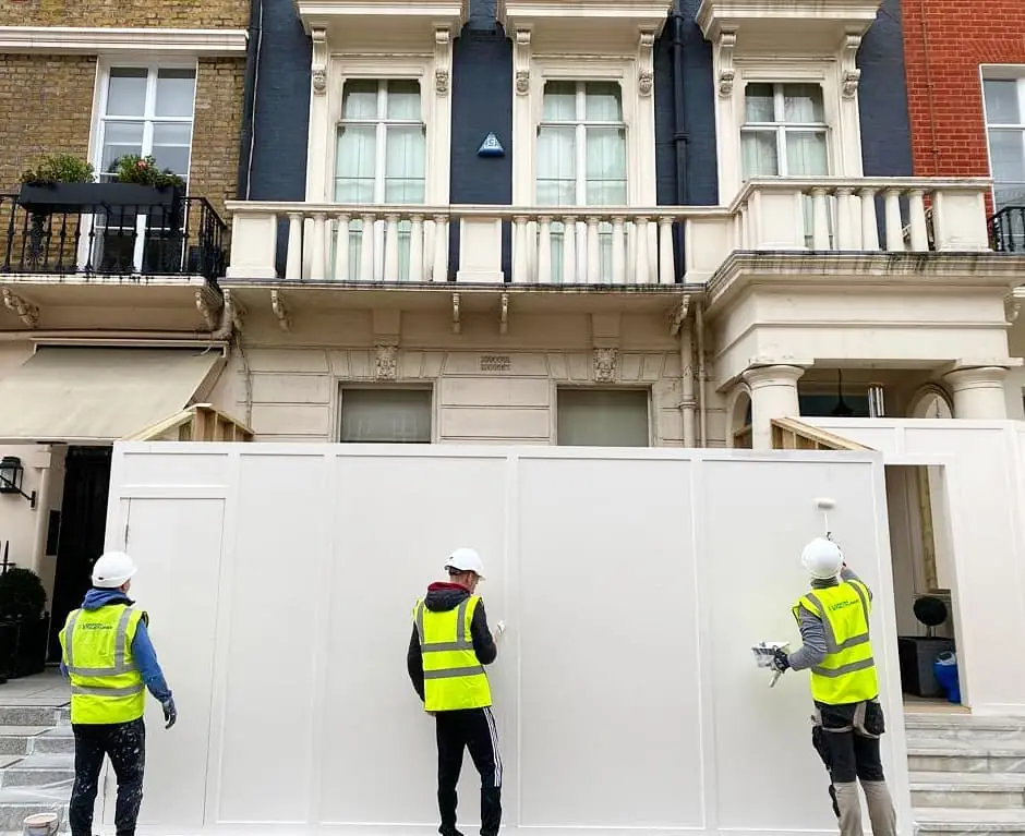 Putting up the hoarding. The Grosvenor Estate sets its size and colour.