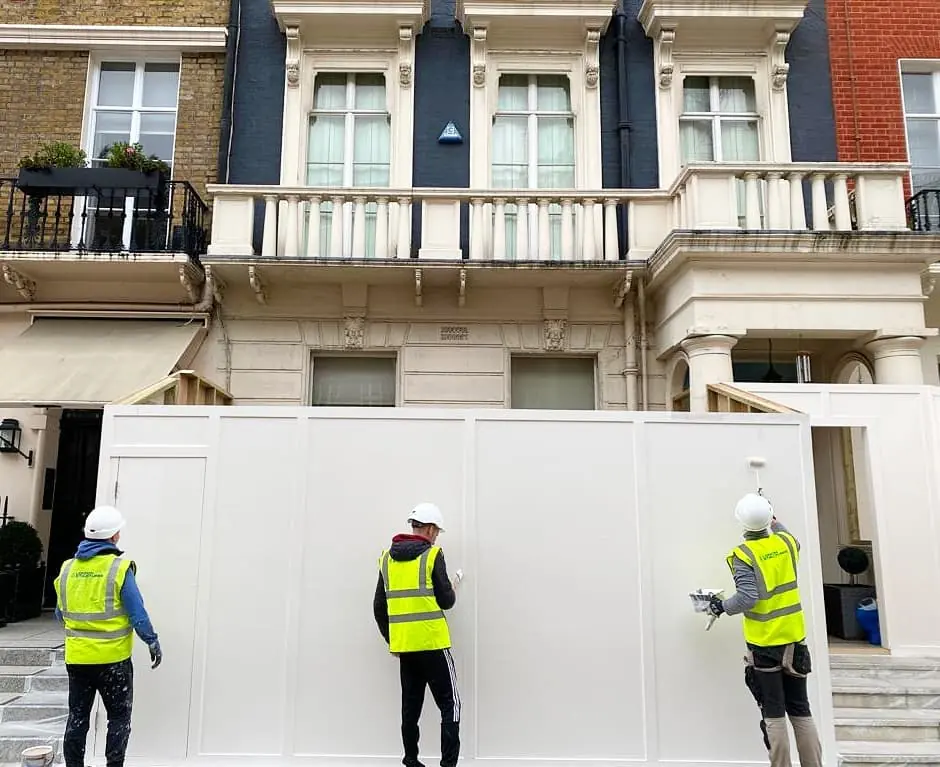 Putting up the hoarding. The Grosvenor Estate sets its size and colour.