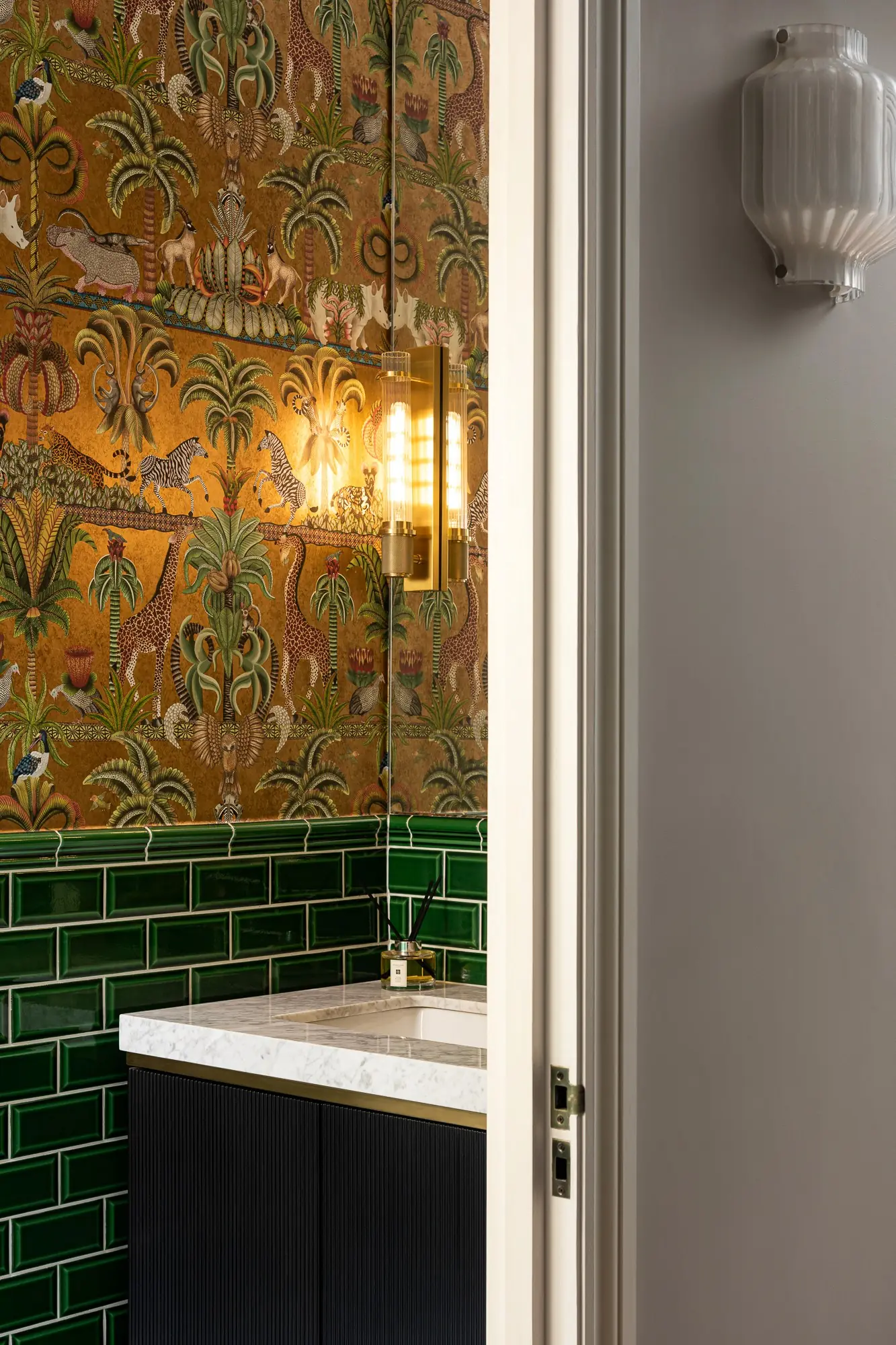 Cloakroom with patterned wallpaper and green tiles