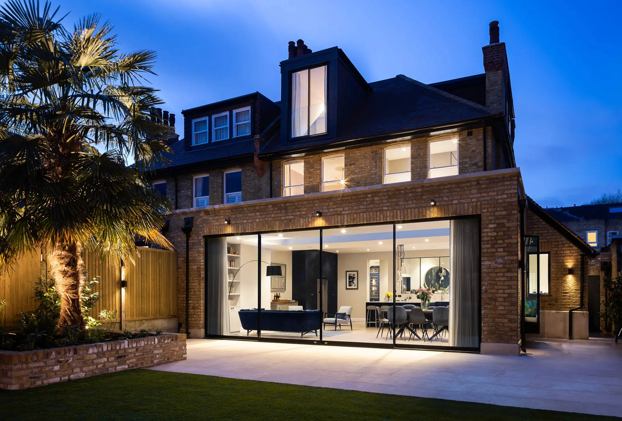 Rear elevation at dusk with the doors lit
