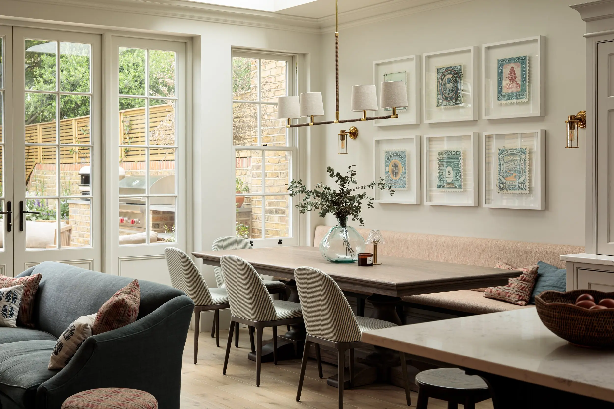 Dining banquette below a gallery of prints