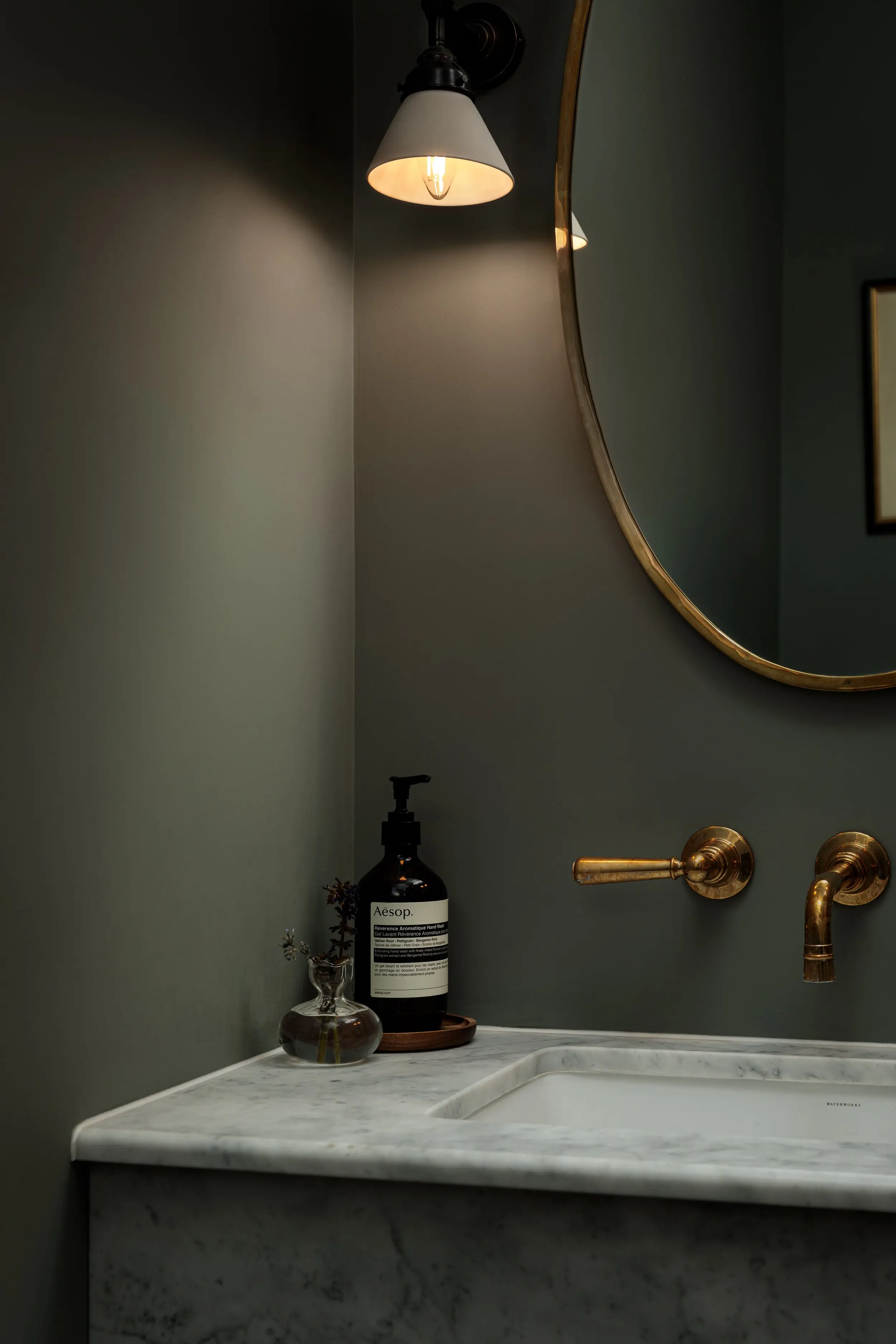 Stone basin and brass mirror in the cloakroom