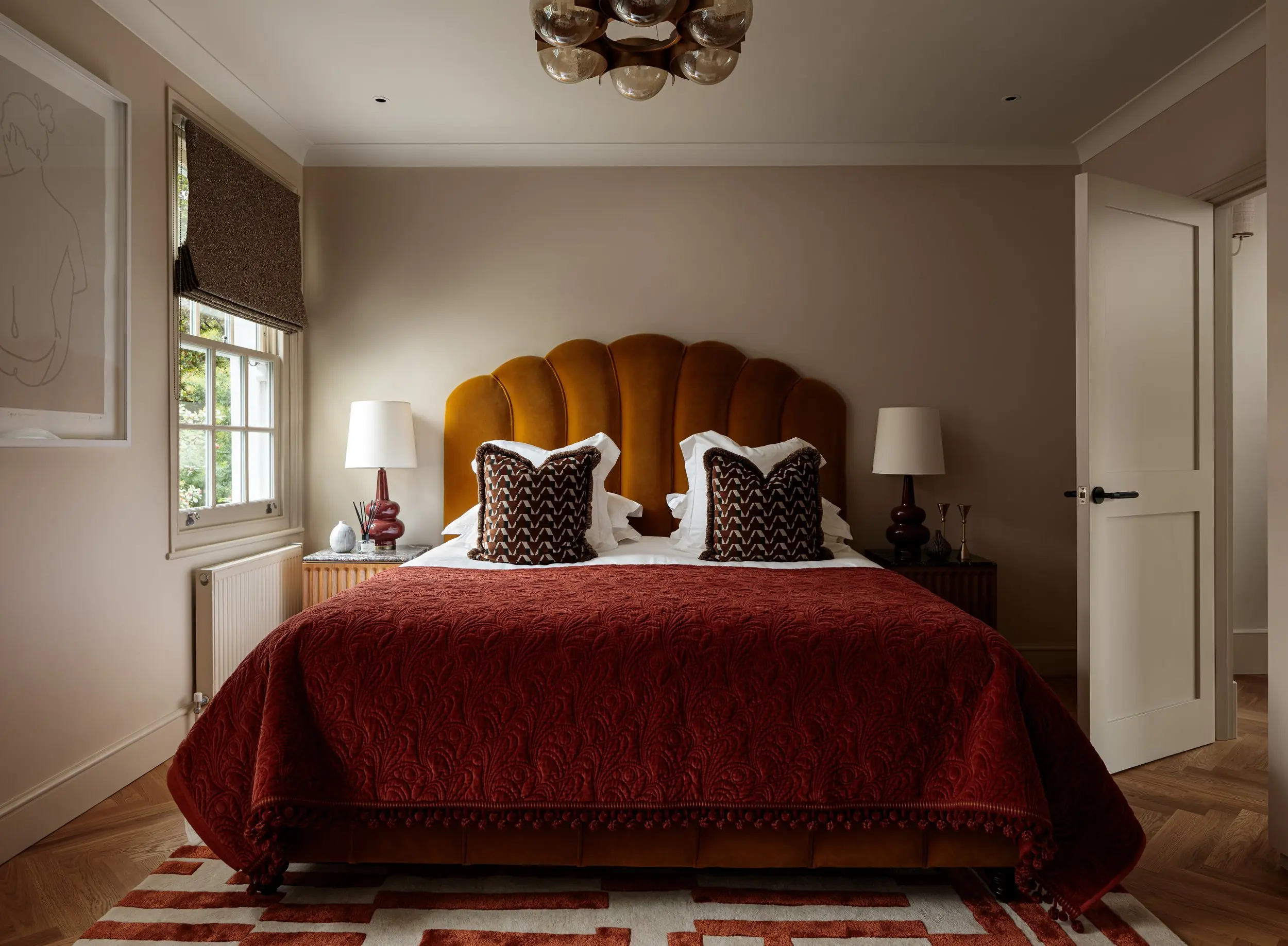 Bedroom with scalloped headboard and red bedspread