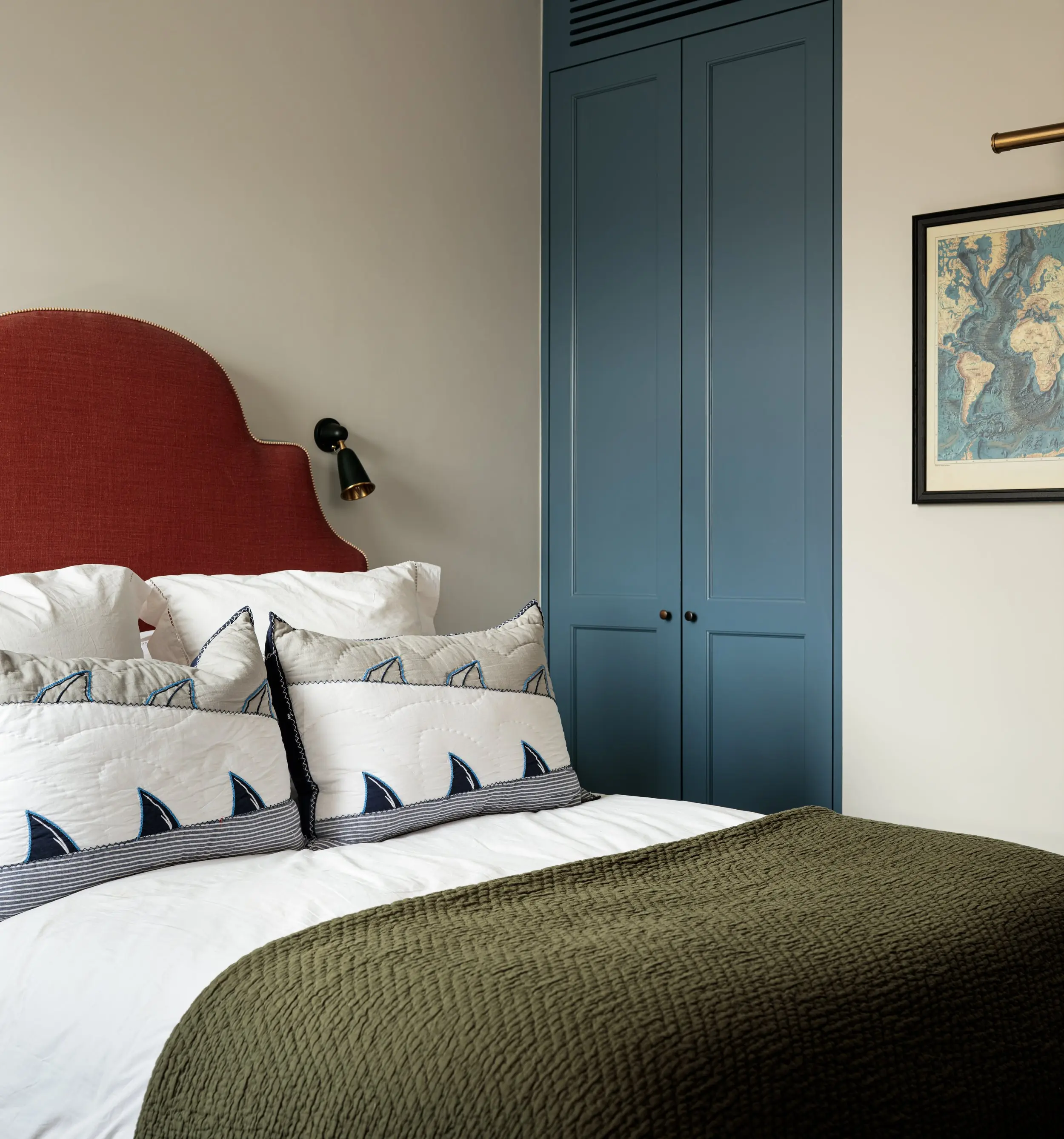 Child's bedroom with red headboard and blue wardrobes
