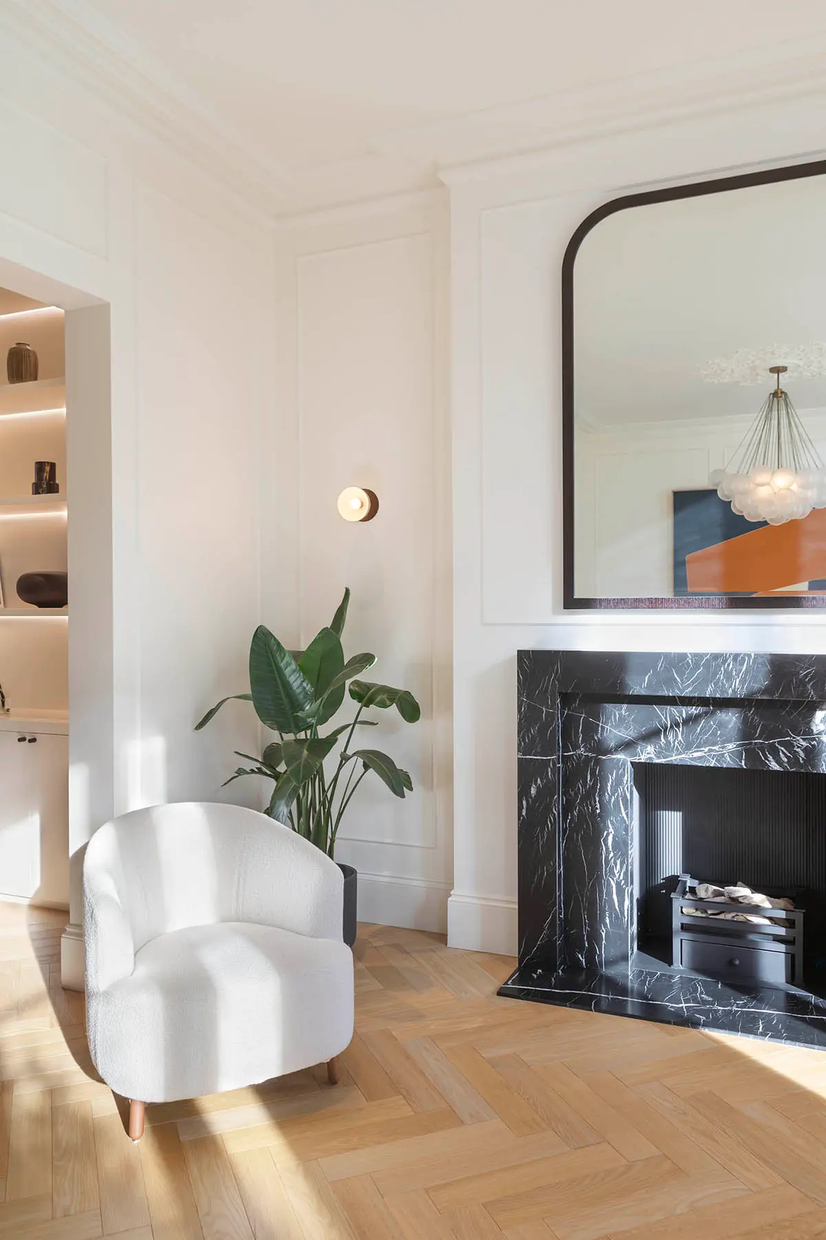 Armchair and mirror by the marble chimneypiece