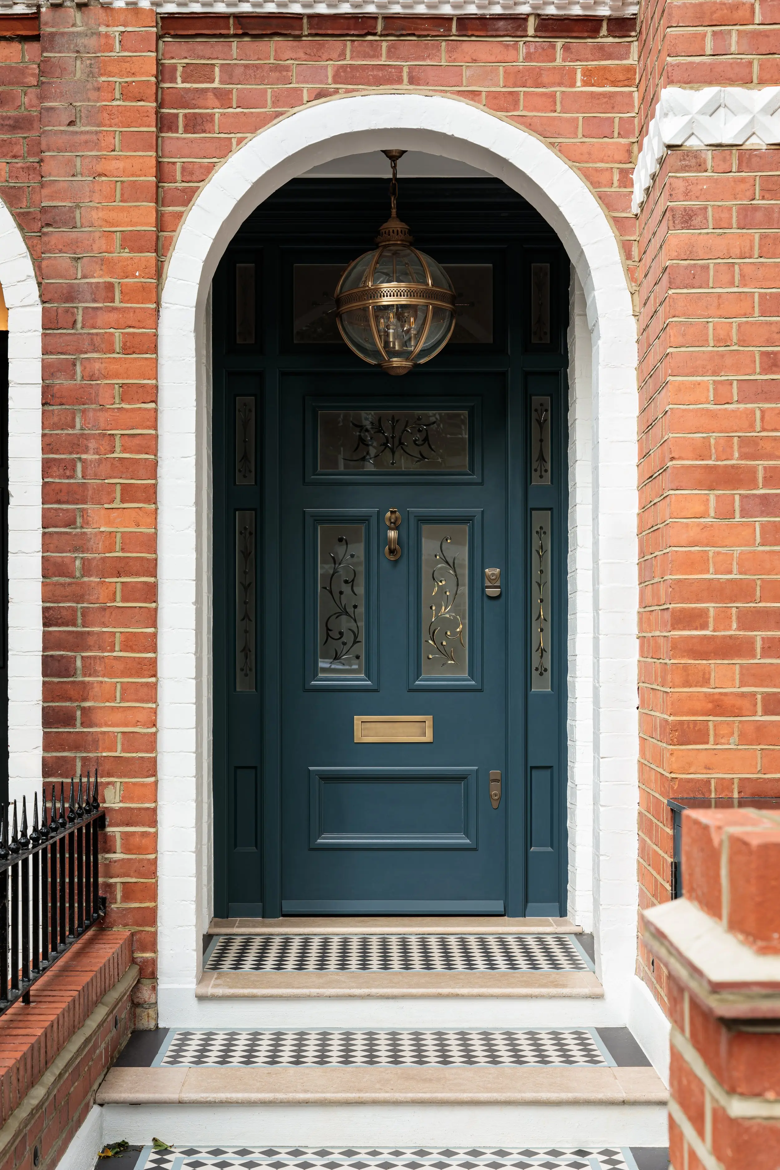 Arched front door under a brass lantern