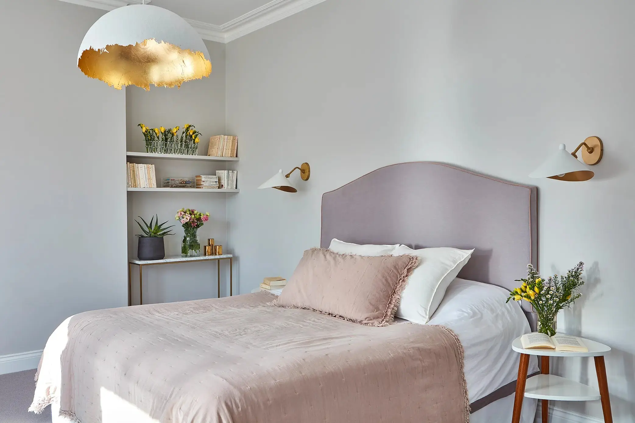 Bedroom with pale headboard and gold pendant