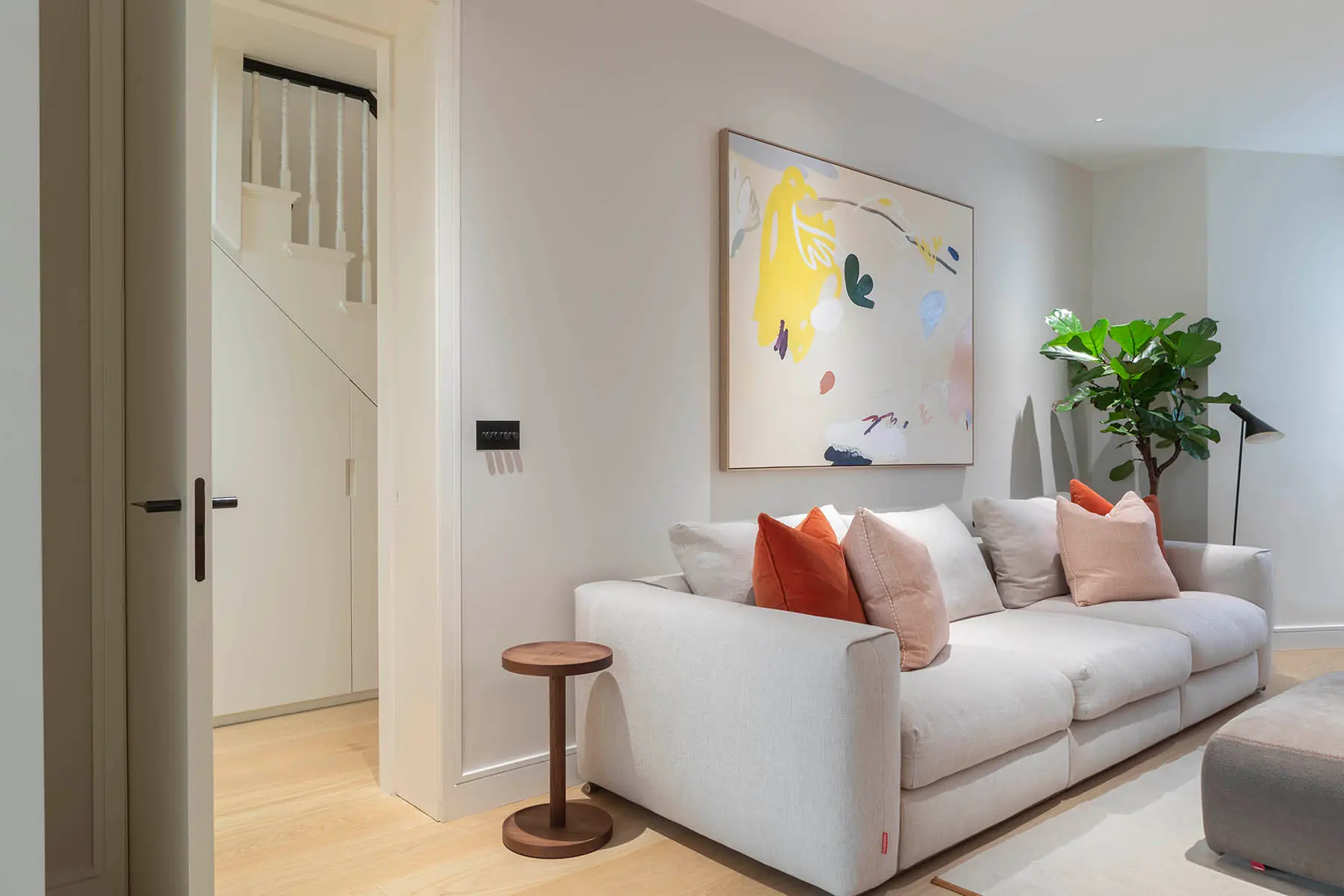 White sofa and artwork beside the stair door